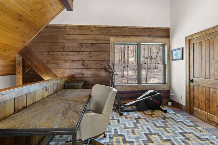 Loft Has a Writing Table and Work Out Equipment
