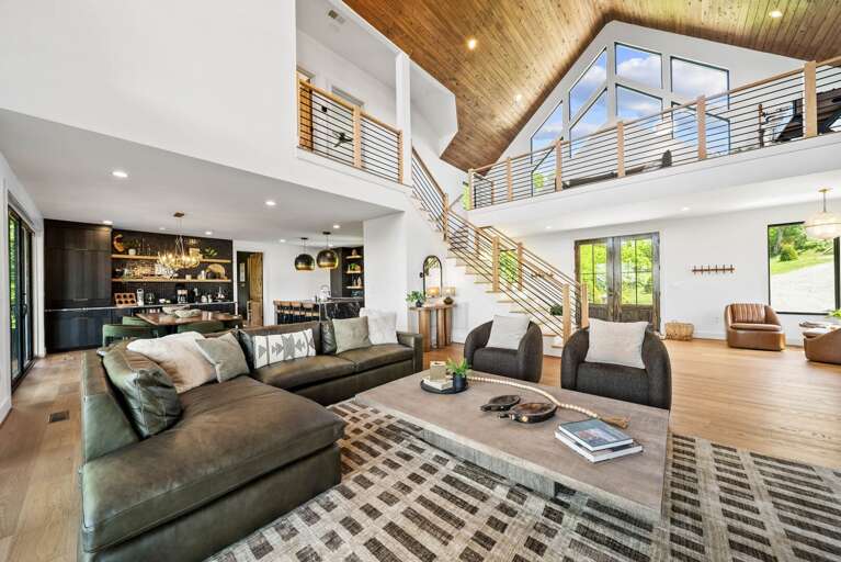 Dramatic Architecture, Warm Wood Accents, and Floor-to-Ceiling Windows on Both Sides.