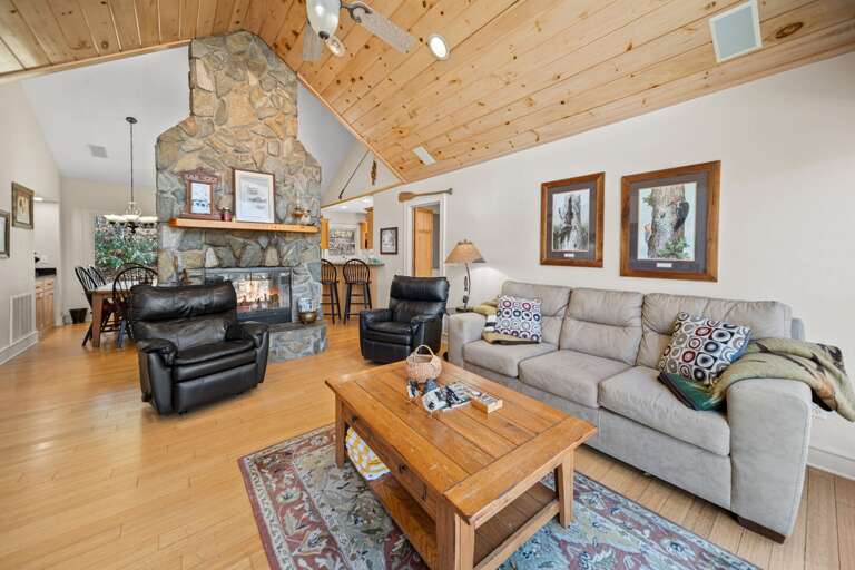 Stacked Stone Wood Burning Fireplace Separates Living Room and Dining Room