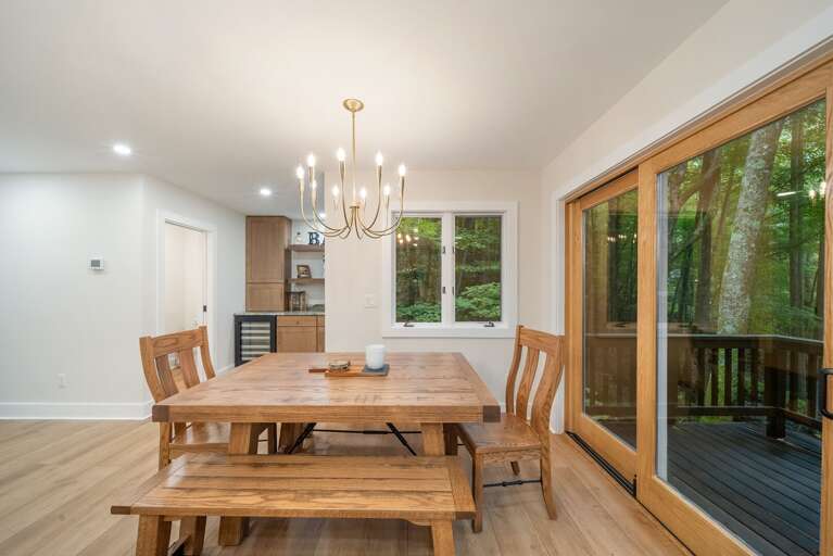 Dining Area with Beautiful Wood Table, Chairs and Benches next to Sliding Doors to the Deck Dining Area with Beautiful Wood Table, Chairs and Benches next to Sliding Doors to the Deck