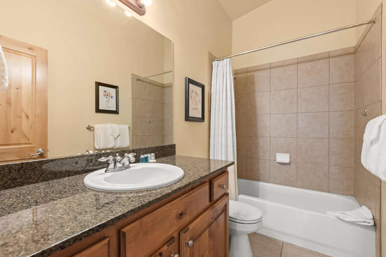 Your private bathroom features a spacious tub-shower combo, granite countertops, and soft linens—a serene retreat after a day of adventure.