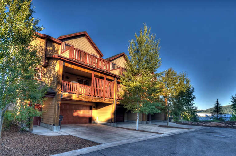A spacious mountain retreat nestled among trees with multiple balconies and convenient parking, offering a peaceful escape from the everyday.