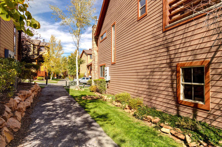 The property is located in a quiet residential neighborhood with well-maintained landscaping, tree-lined walkways, and nearby parking, offering a peaceful retreat setting.