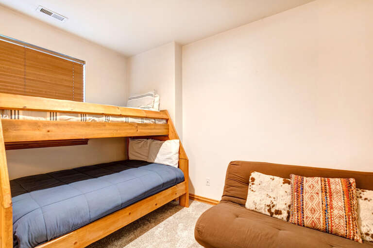 Your bunk room offers cozy sleeping arrangements with soft linens and a relaxing seating area, perfect for winding down after a day of adventure.