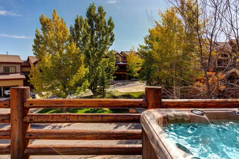 Private hot tub on the deck with autumn foliage and peaceful neighborhood views—your perfect spot to unwind after a day of exploring.