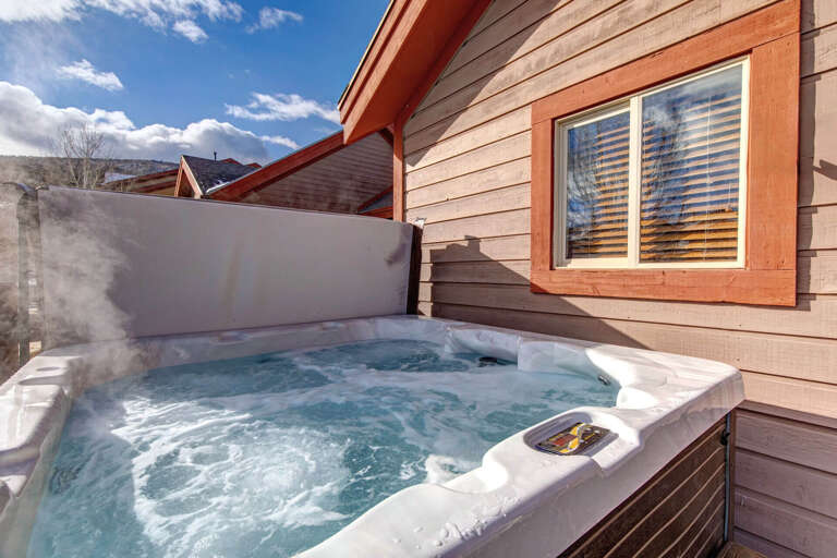 Sink into your private hot tub under bright blue skies, where warm bubbles and mountain breezes melt tension away on this sunny terrace.