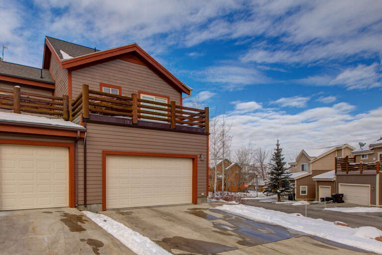 This charming mountain retreat features modern architecture with warm wood tones and an upper-level deck for outdoor relaxation. Convenient parking and a peaceful neighborhood setting complete the picture.