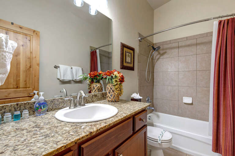 Step into your private bathroom with granite countertops, warm wood cabinetry, and a relaxing tub-shower combo—everything you need to refresh after a day of adventure.