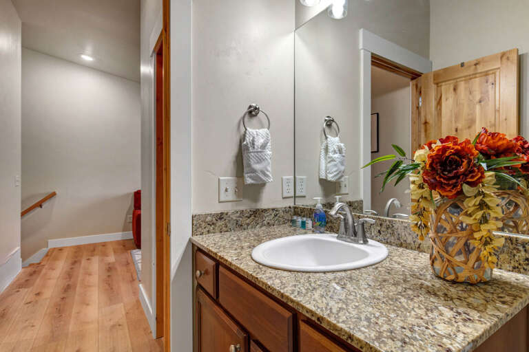 Your private bathroom features a granite vanity, fresh towels, and thoughtful touches like flowers—clean, bright, and ready for your arrival.