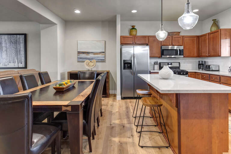 Your open-concept kitchen and dining area invites memorable meals with modern appliances, warm wood cabinetry, and elegant pendant lighting creating the perfect gathering space.