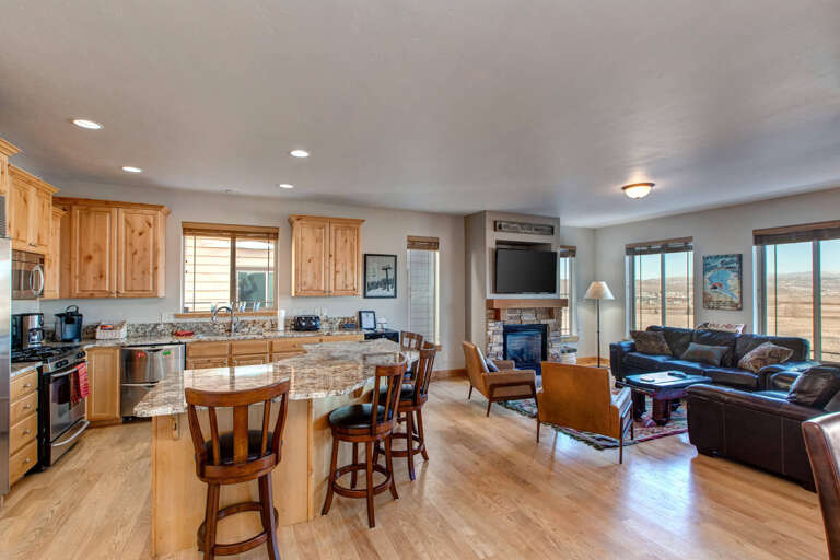 Spacious open-concept living with sweeping landscape views, a fully-equipped kitchen featuring granite counters, and a cozy fireplace anchoring your relaxation space.