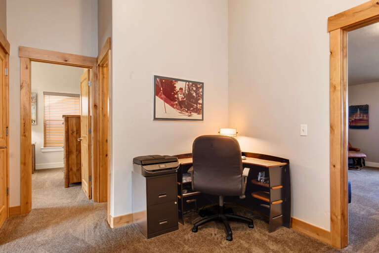 Your dedicated work nook with a cozy desk lamp and everything you need to stay productive, tucked into a quiet corner near the bedrooms.