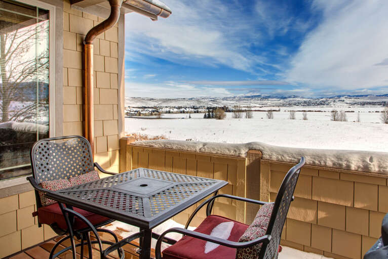 A private balcony overlooking expansive snow-covered fields and distant mountains provides a serene mountain escape where you can enjoy your morning coffee in crisp, fresh air.