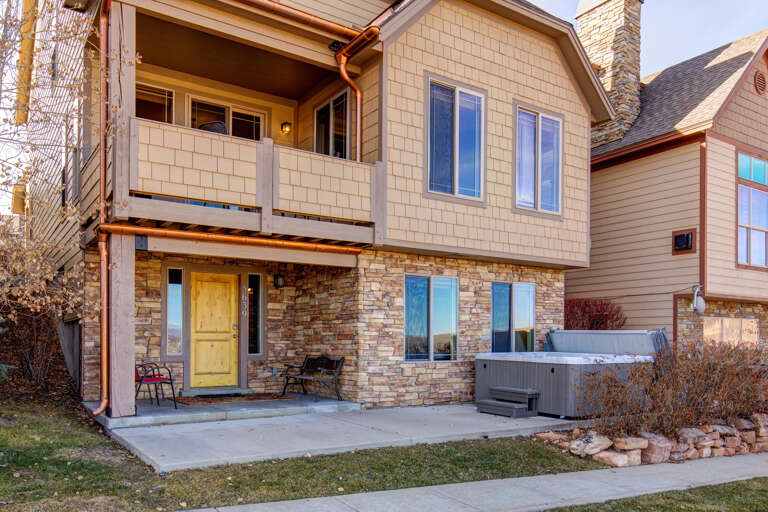Charming two-story vacation retreat featuring stone accents, a private hot tub, and a spacious balcony overlooking the neighborhood.