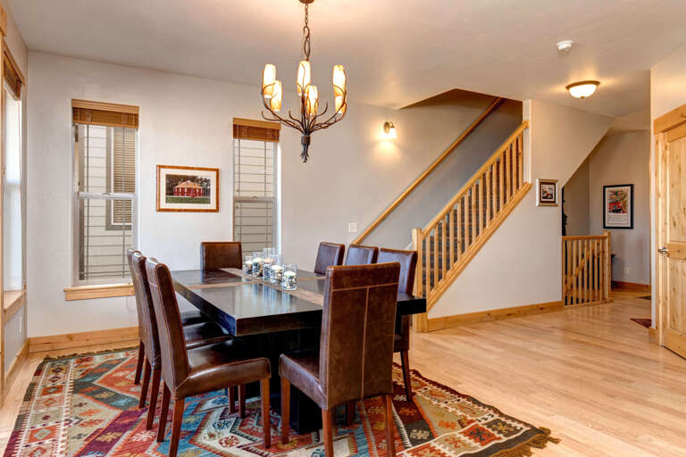 Bear Hollow Village 5639: Inviting dining table by elegant staircase, perfect for family gatherings. Bear Hollow Village 5639: Inviting dining table by elegant staircase, perfect for family gatherings.