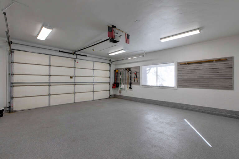Spacious two-car garage with epoxy flooring, organized wall storage, and convenient interior access—perfect for parking and storing your gear.