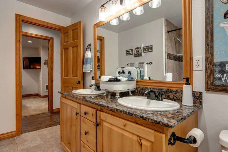 Unwind in your spacious bathroom with dual sinks, warm wood cabinetry, and a refreshing walk-in shower—perfect for freshening up after mountain adventures.