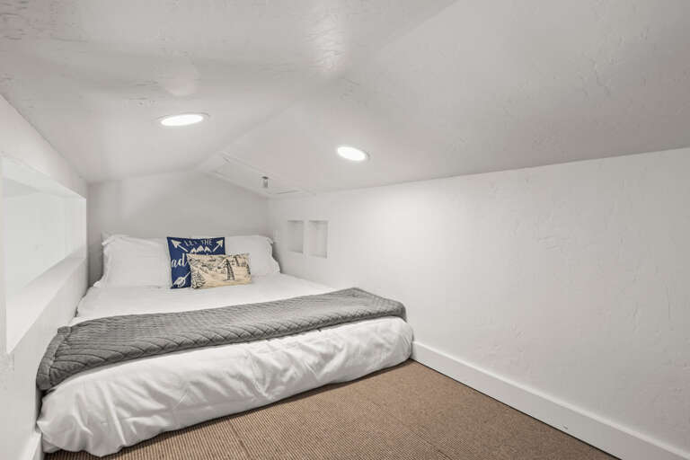 Drift into peaceful sleep in your cozy loft bedroom, where crisp linens and soft lighting create the perfect mountain getaway retreat.