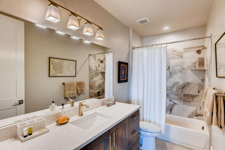 Step into your sleek, modern bathroom with luxurious finishes. Crisp white counters, warm tones, and thoughtful details create a spa-like retreat for your daily refresh.