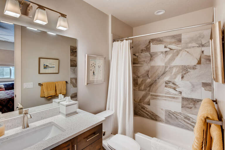 Step into your private bathroom with elegant marble-look tiling and modern fixtures. Fresh towels and thoughtful details create a spa-like retreat where you can unwind after exploring the area.