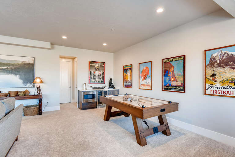 Challenge your travel companions to a friendly match on the game table, surrounded by vibrant vintage ski posters that add a playful mountain charm to your downtime.