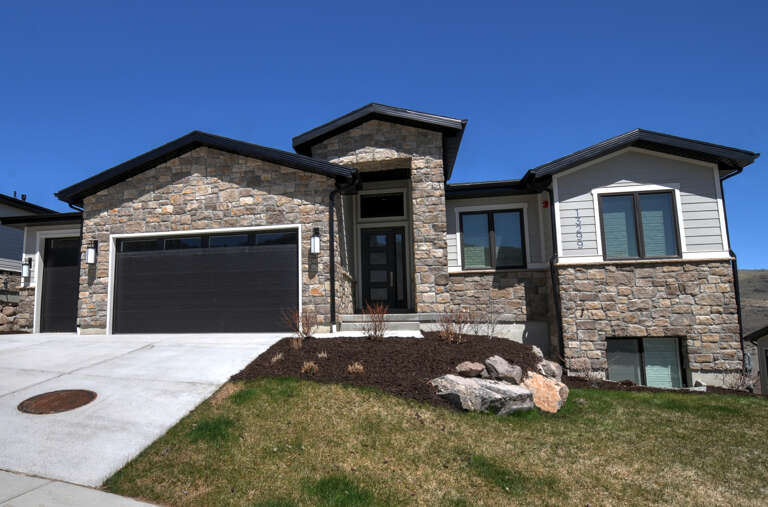 A striking stone and modern siding exterior welcomes guests to this spacious vacation rental, nestled in a peaceful neighborhood with mountain views and convenient parking.