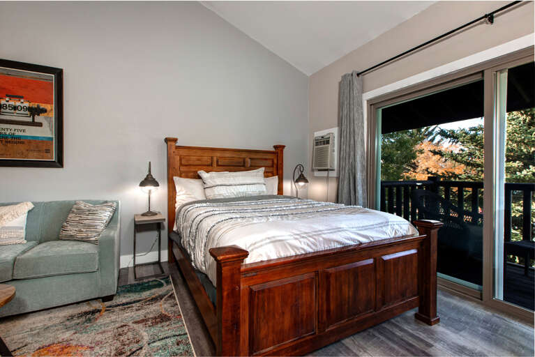 Cozy queen bed with access to a charming outdoor patio area. Cozy queen bed with access to a charming outdoor patio area.