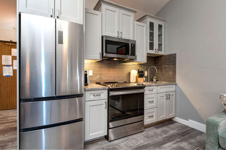 sleek electric range, fridge, microwave, ample cabinets, and countertops. sleek electric range, fridge, microwave, ample cabinets, and countertops.