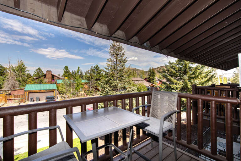 Relax in nature's embrace with two chairs and a cozy table.