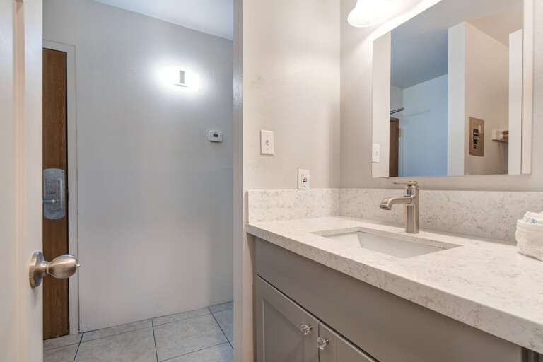 Sleek sink, mirror, bright light, ample space for your daily routine.