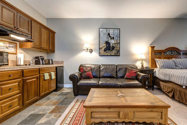 Cozy space with a sofa, center table, and kitchen view. Cozy space with a sofa, center table, and kitchen view.