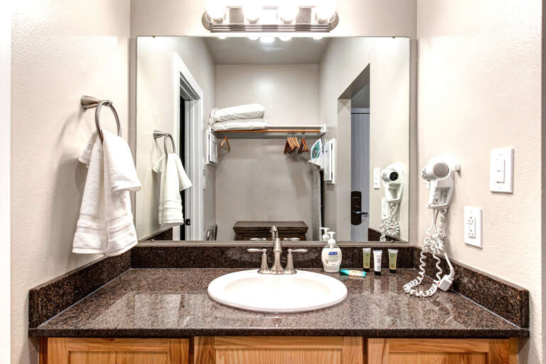 Bathroom: Sleek sink, hair dryer, and overhead lights Bathroom: Sleek sink, hair dryer, and overhead lights
