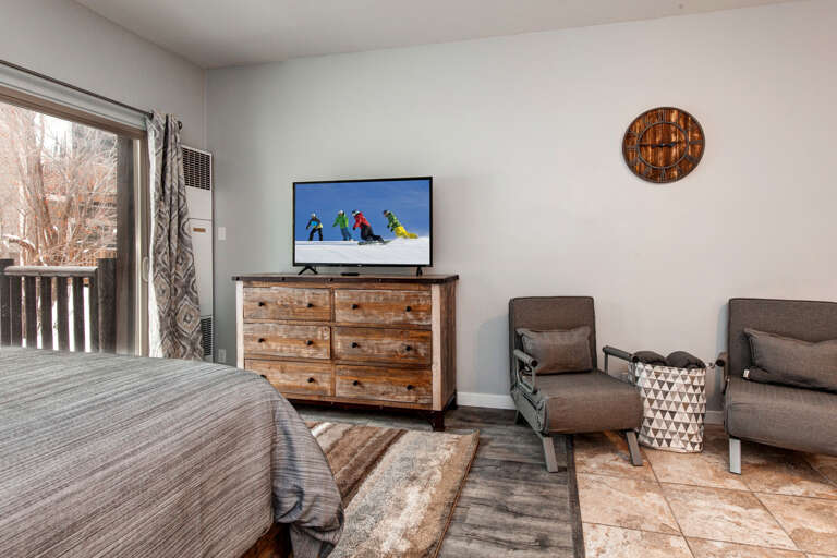 Cozy queen bed with TV and cabinet for a relaxing stay.