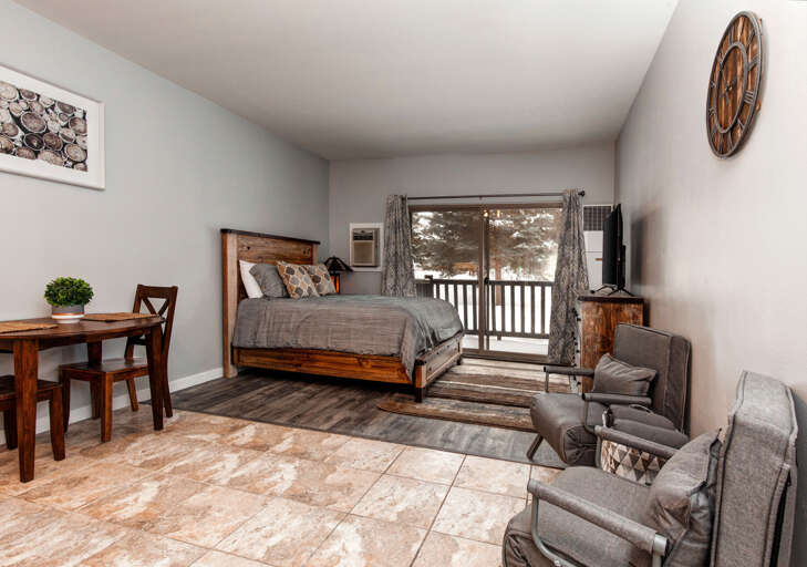 Queen bed, 2 sofa chairs, outdoor patio, and TV bliss.