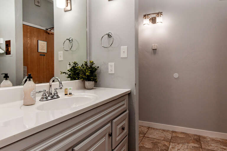 Reflective sink area with a sleek mirror, perfect for morning routines.