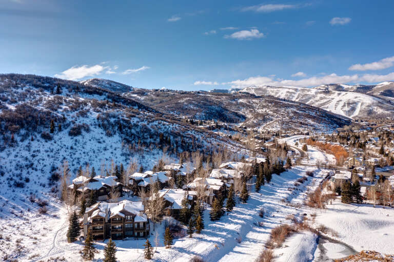 Scenic mountain valley property nestled among snow-covered slopes and evergreen forests, with winter recreation nearby.