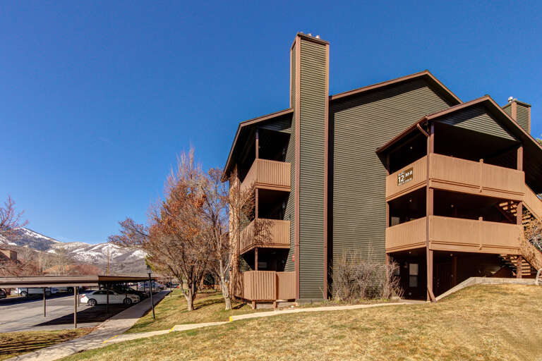 Multi-story vacation rental building with mountain views and covered parking, set in a scenic area with convenient access to local attractions.