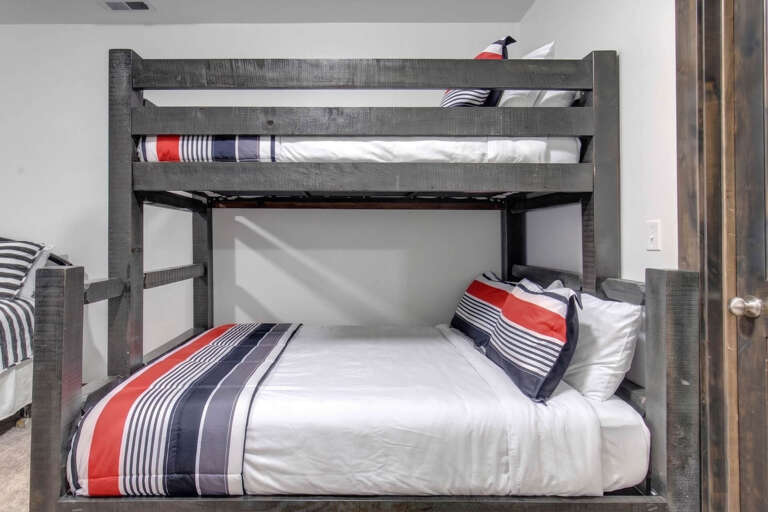 Settle into this stylish bunk room, where fresh linens in bold stripes await. Perfect for extra guests or kids, this cozy sleeping nook offers comfort and smart use of space.