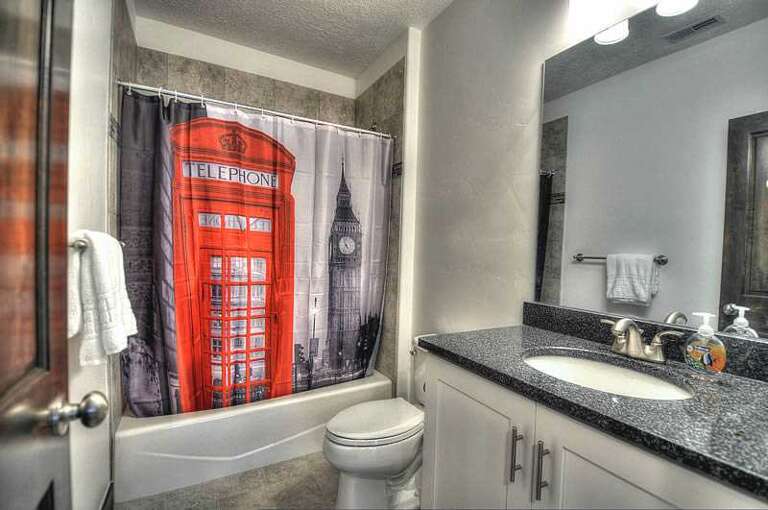 Your bright, modern bathroom offers a sleek gray vanity, fresh towels, and a full tub-shower combo ready for a refreshing start or relaxing end to your day.