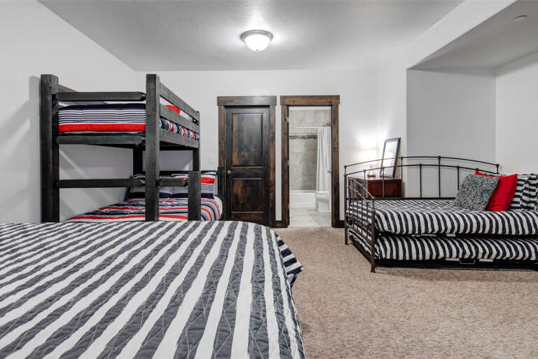 Your group will love this spacious bunk room with bold striped bedding and rustic wood accents. Multiple sleeping spaces ensure everyone rests comfortably after a day of adventure.