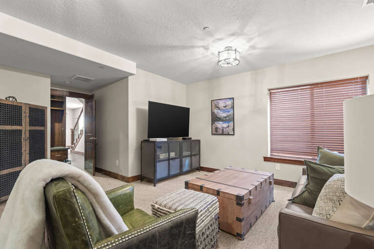 Sink into plush seating in this inviting lower-level retreat, where your favorite shows await on the flat-screen TV. The warm wood accents and natural light create a cozy spot to unwind after a day of adventure.