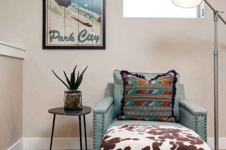Curl up in your cozy reading nook with a good book. Soft natural light streams through the window, warming the inviting textured pillows and chic western-inspired decor.