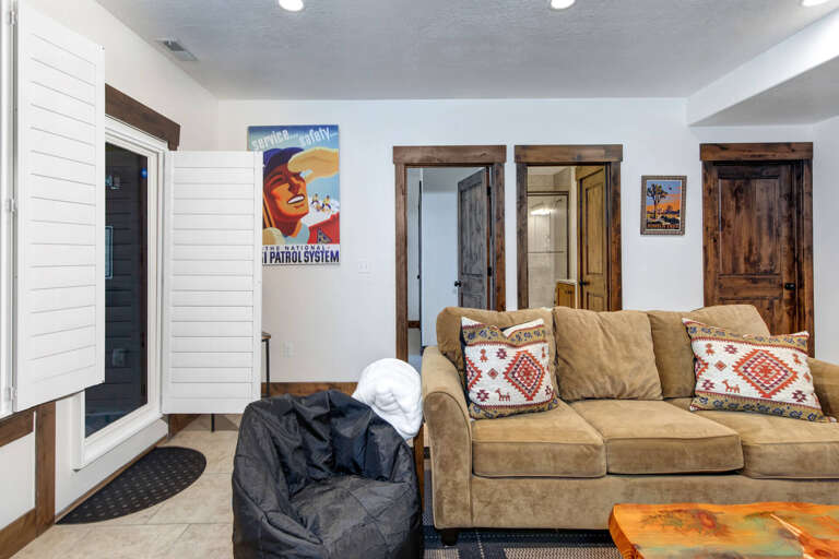 Your cozy living space awaits with a plush sofa, vibrant decor, and rustic wood doors that add mountain charm. Sink into comfort after your adventures and make yourself at home.