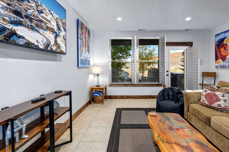 Gather here for cozy evenings with ski-themed art, a plush couch, and French doors opening to desert views that frame your mountain getaway.