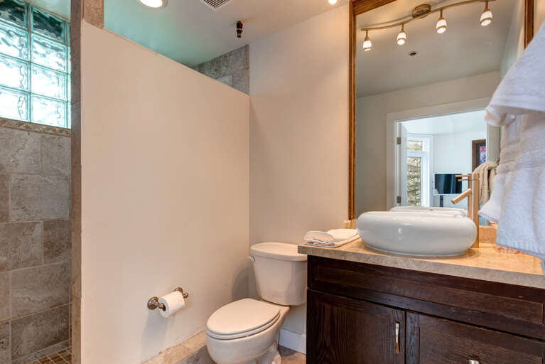 Step into your beautifully appointed bathroom, where modern elegance meets comfort. The vessel sink and thoughtfully placed towels create a welcoming retreat for your stay.