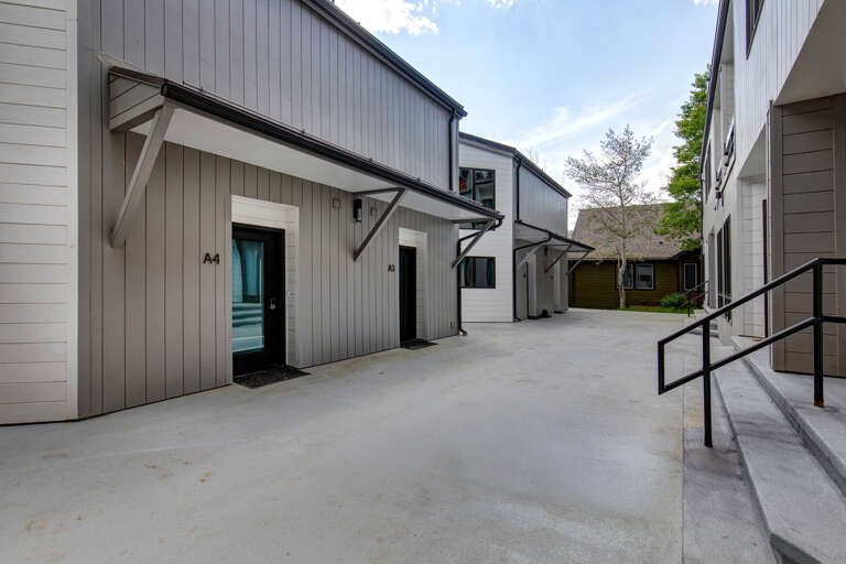 Modern property building featuring multiple units with clean architectural lines, open courtyard, and convenient ground-level access in a peaceful residential setting.