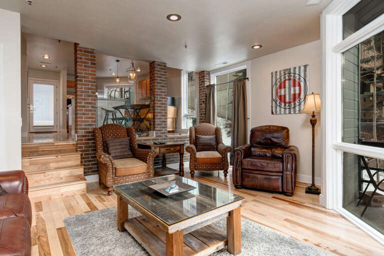 Sink into rich leather and woven chairs in your bright living room, where exposed brick columns add rustic character and sunlight streams through generous windows.
