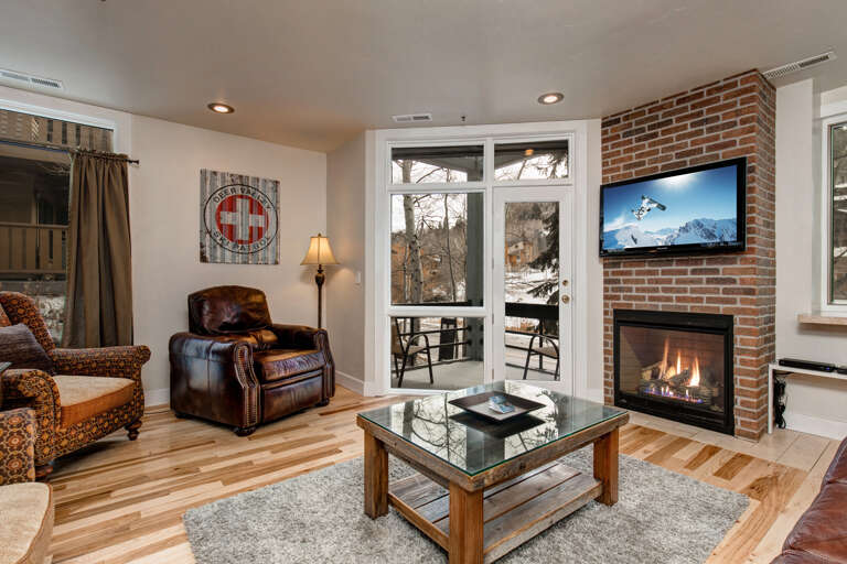Unwind in your mountain retreat with a cozy fireplace, plush seating, and your own private balcony overlooking snowy peaks and winter pines.
