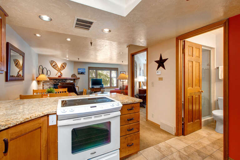 Modern electric range, sleek kitchen tops, cozy living room proximity.