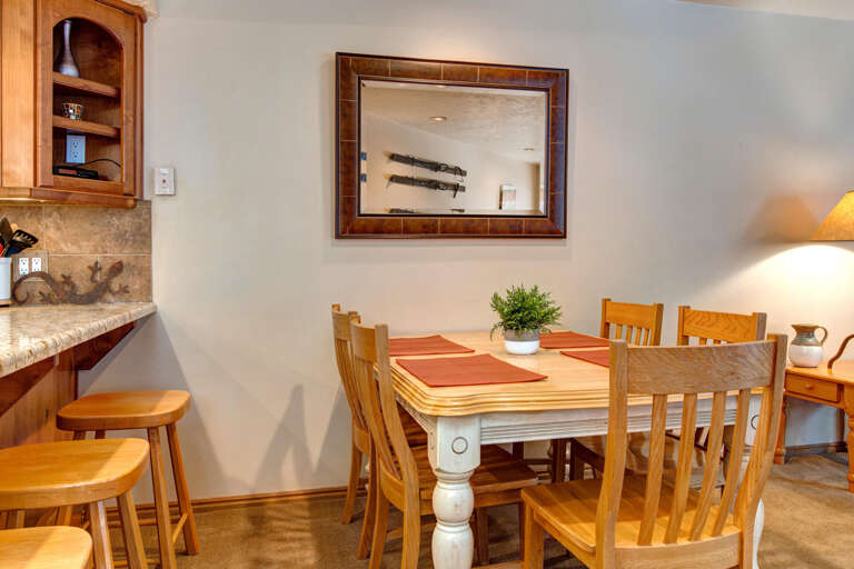Rustic wood table and bar stools create cozy dining ambiance.